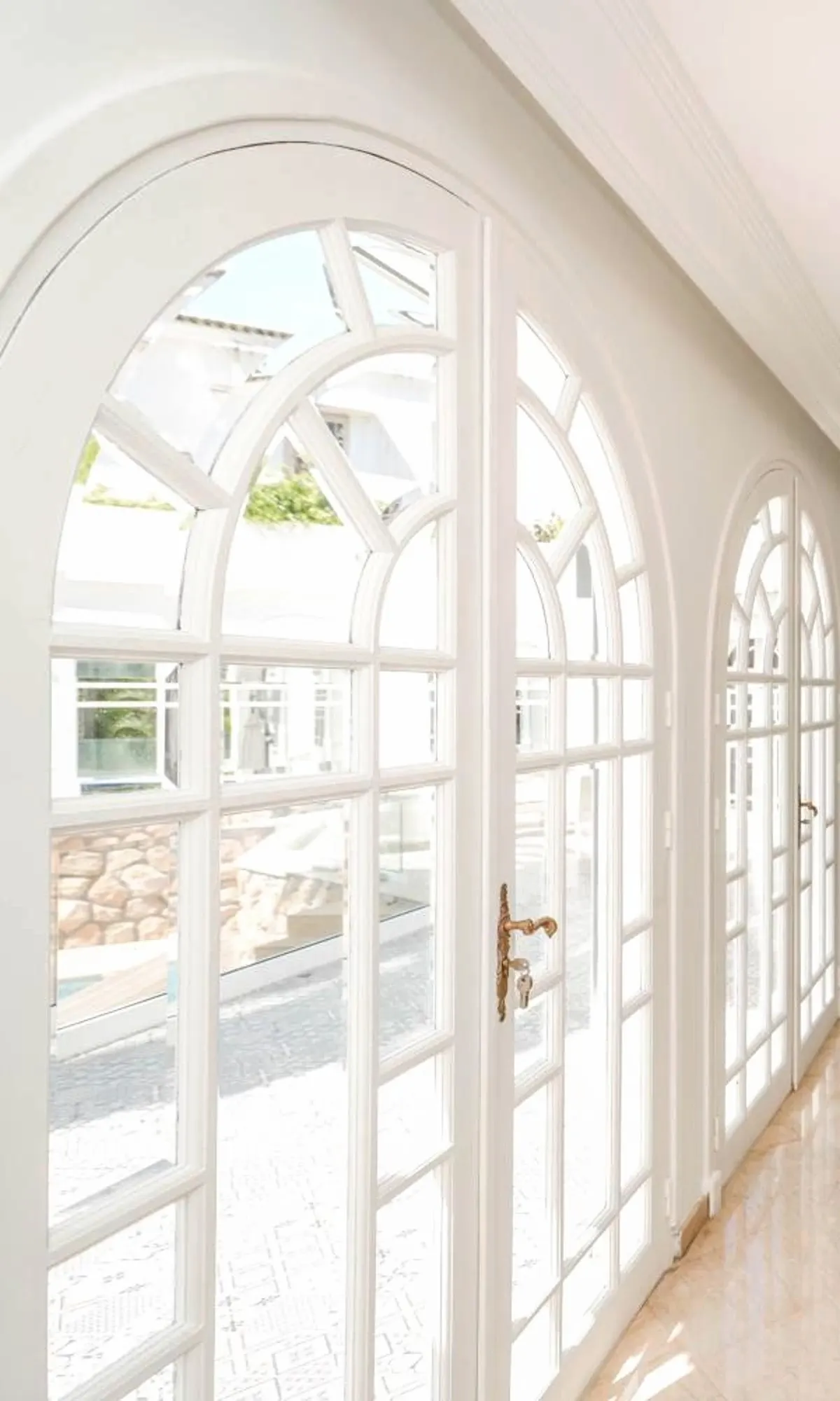 Arched French windows with white glazing bars along the gallery.