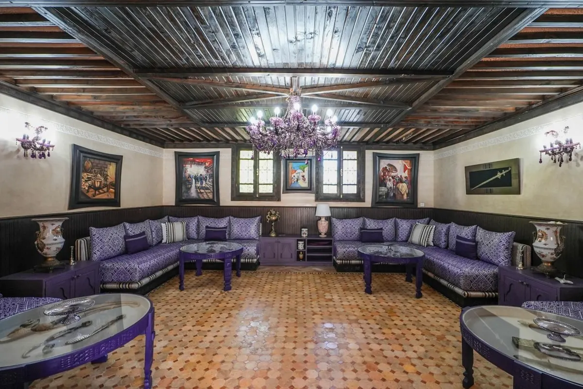 The tea salon: violet banquettes under a painted-beam ceiling.