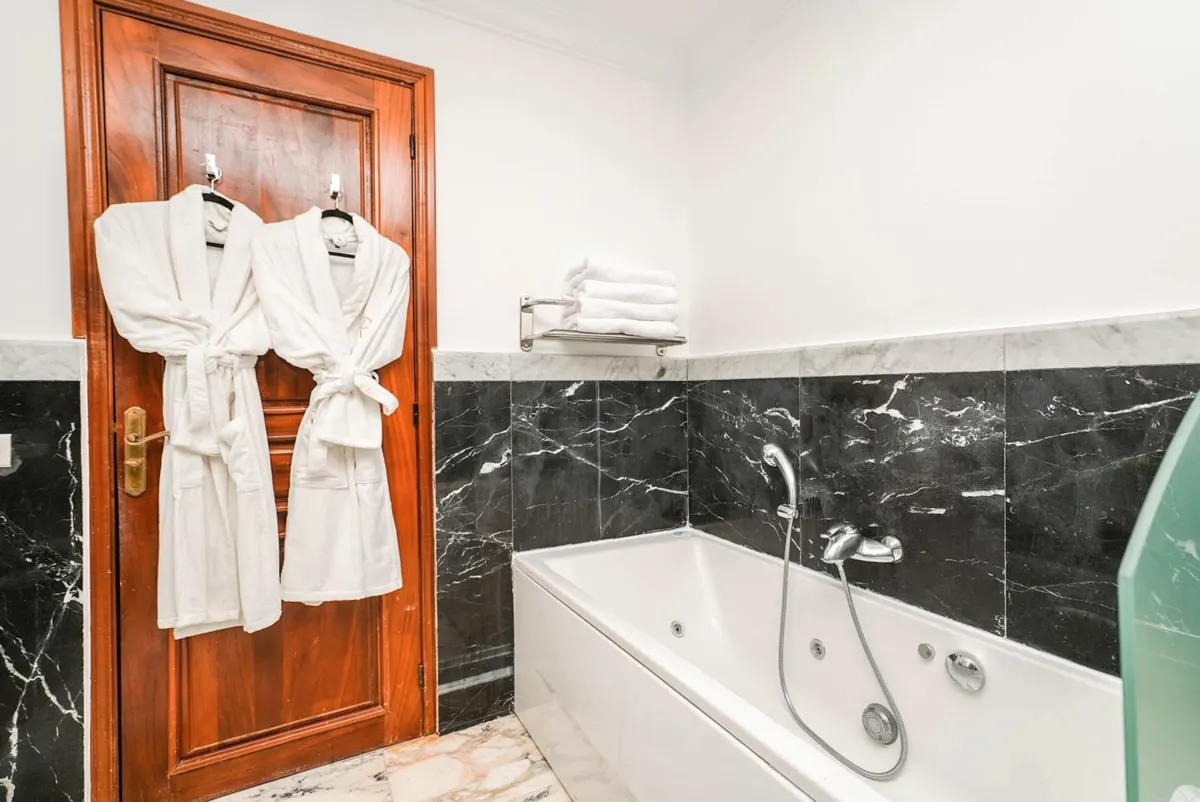 Family Studio: spa bath in black marble, bathrobes on the door.