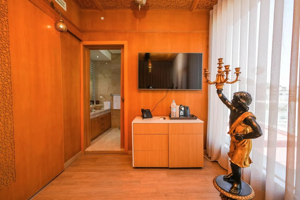 Deluxe Suite: orange-lacquered panelled wall with a figurative torchère.