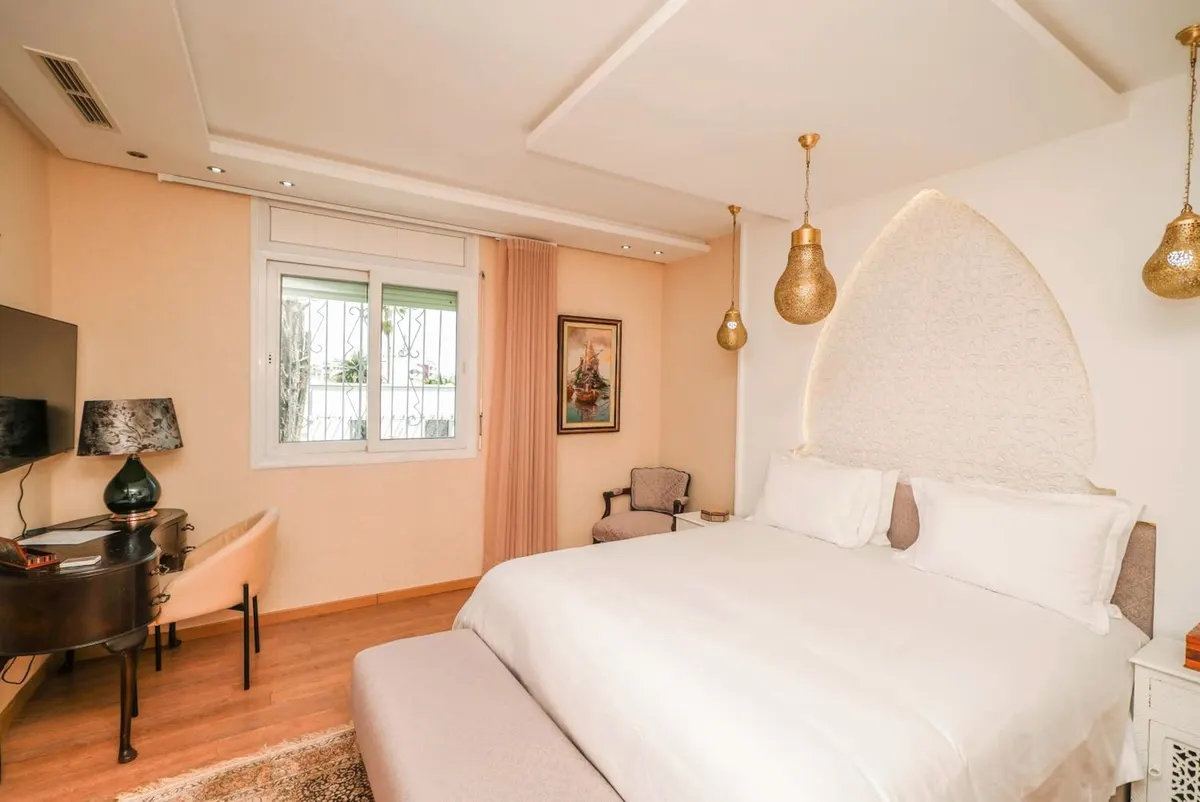 Deluxe Suite: bedroom with desk and window.