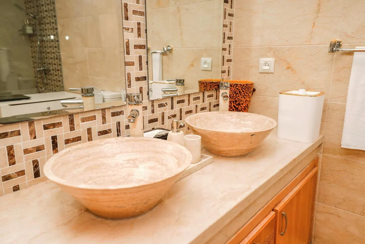 Deluxe Suite: two stone vessel basins and a mosaic splashback.
